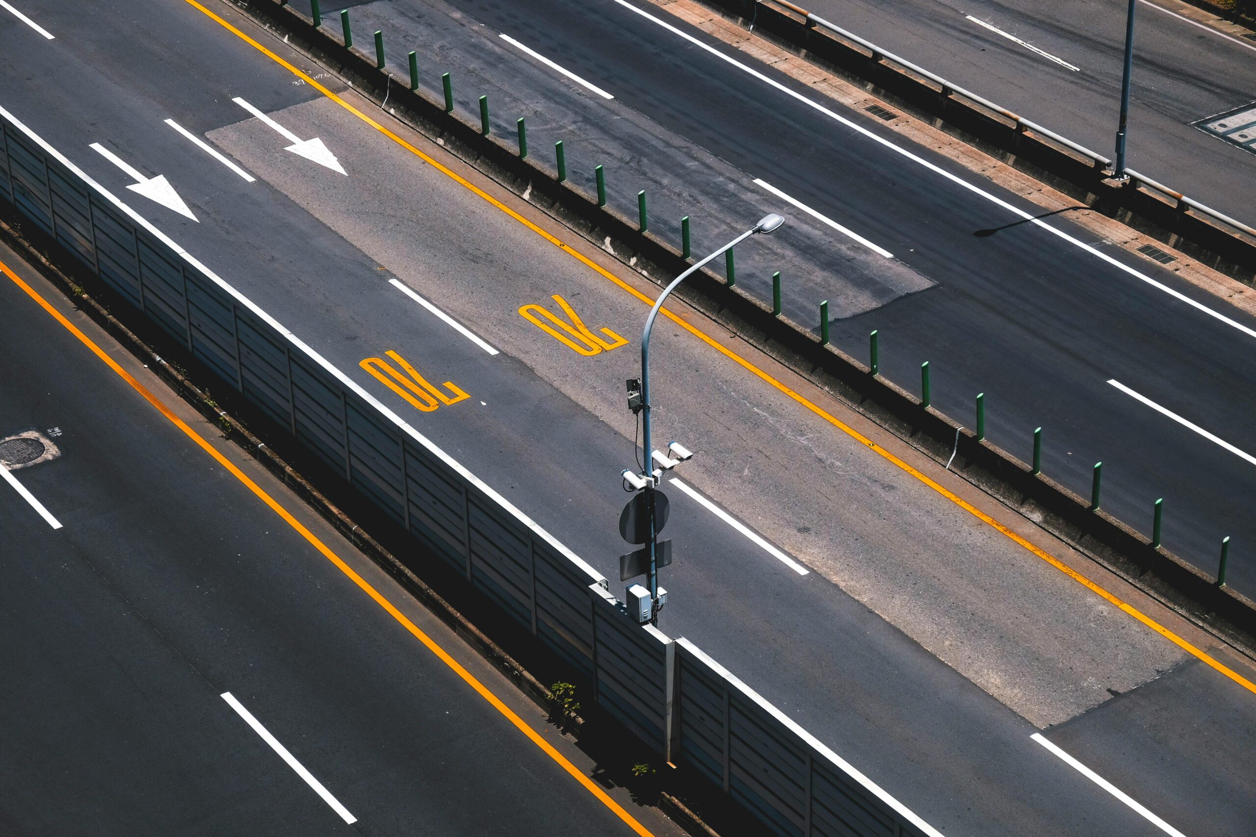 pexels photo 1258357 1258357 Aerial view of a modern highway with clear lane markings and street lights.