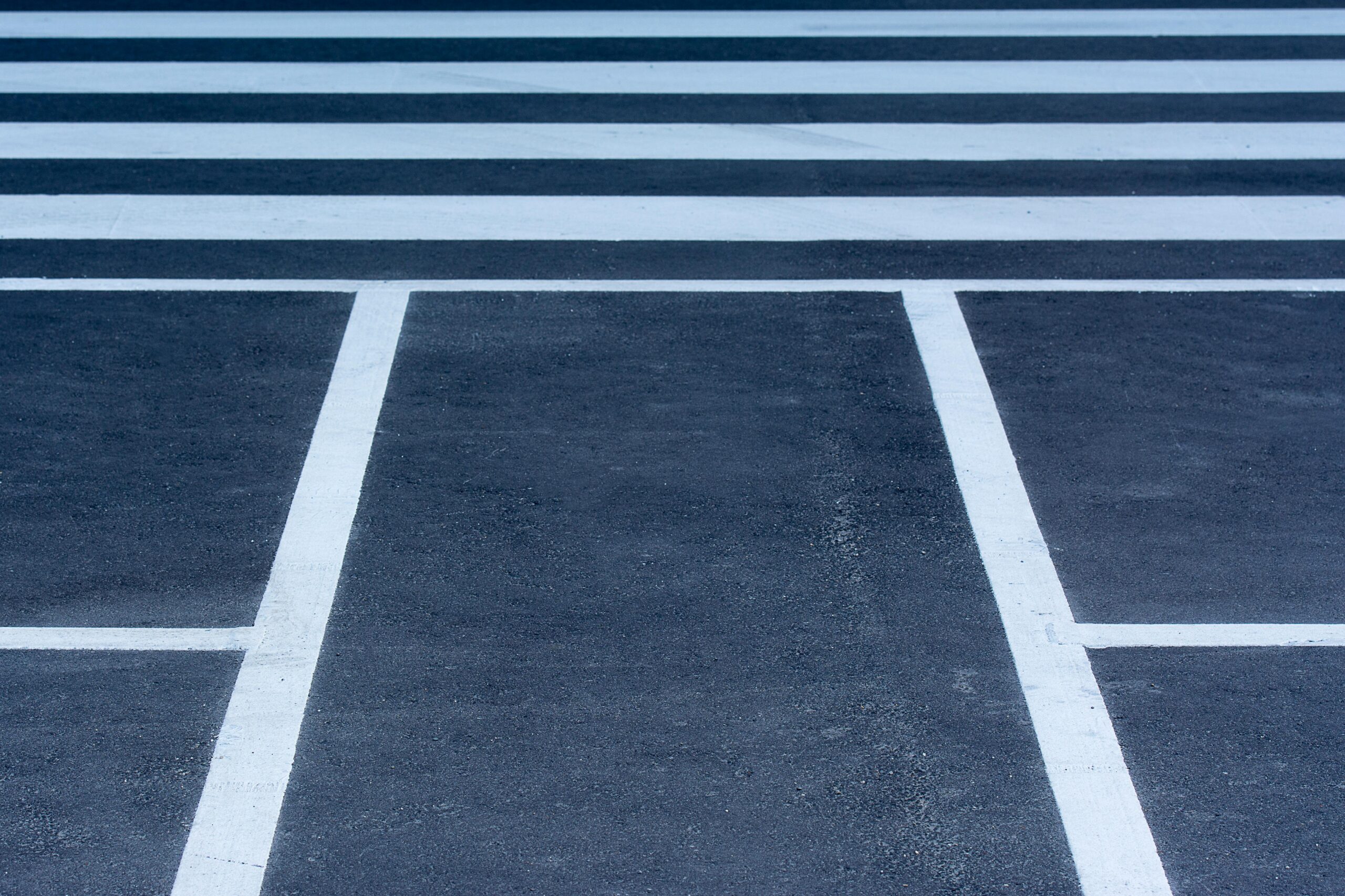 pexels photo 13749873 13749873 A detailed view of a zebra crossing and road markings on an urban asphalt street.